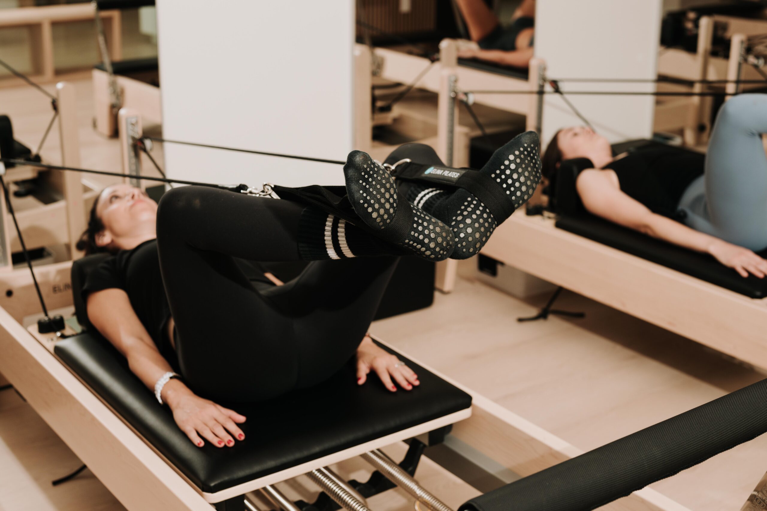 Feet in the straps on the Reformer during a YA FIT Pilates class